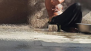 Indian sister-in-law is bathing in the open courtyard of the house, putting a finger in her burrow and rubbing the body, sister-in-law is washing the bathroom.