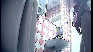 Stunning tall blonde lady in pink dress pissing in the toiletroom