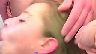 A Barrage of Facial Cumshots While She Sits Encircled by Many Cocks