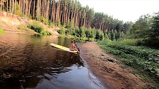Tattooed Babe Strips and Swims on a SUP Board in the Forest