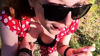 Kinky redhead with big tits gives a blowjob outdoors