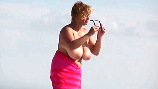 Beach voyeur captures big boobed mature woman sunbathing