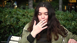 Young Brunette Is Taking an Unhurried Stroll with Allwhite 120mm Cigarette