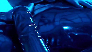 Tied up rubber girl in catsuit fucking herself