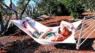 Red XXX stuffs her pussy with a toy in the hammock