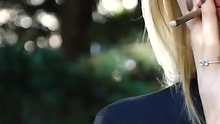 Hot Blonde Babe Smoking Two Black Cigarettes in Nature