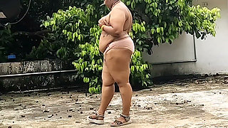 A Full-figured Woman in a White Skirt and Pink Top Strips Down and Walks Nude Outside