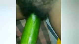 A Young Woman Is Inserting a Cucumber Into Her Pussy